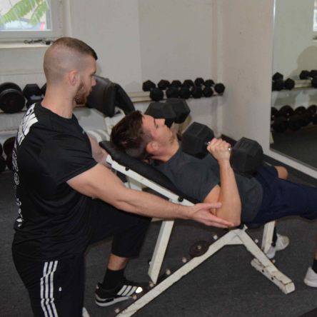 Personal Training mit Lukas Paszkowsky beim Fitnesstraining mit Kurzhanteln auf der Schrägbank.